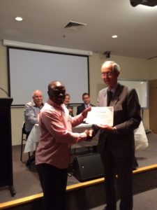 visiting scientist and PhD candidate Kenneth Mbene receiving certificate from SA Committee Chair John Radcliffe